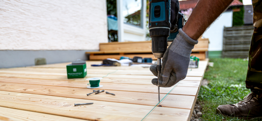 Man drilling tox drive stainless steel screws into deck