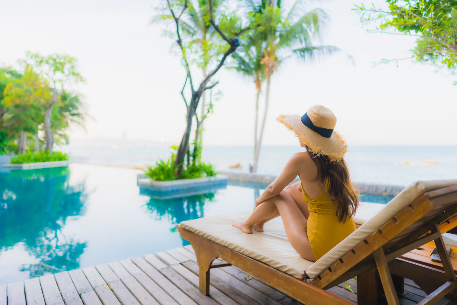 girl in yellow swimsuit on deck chair by pool