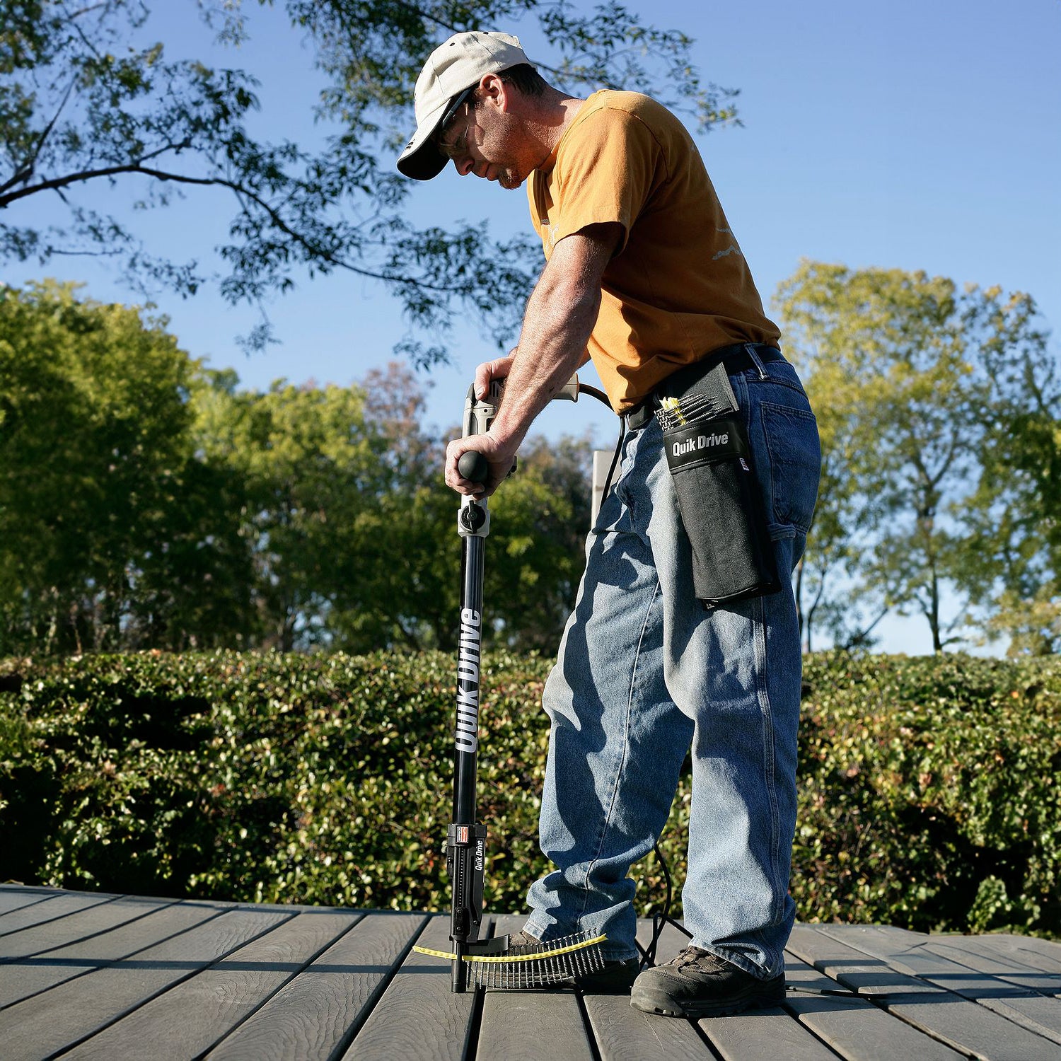 Worker using simpson quik drive system on composite decking