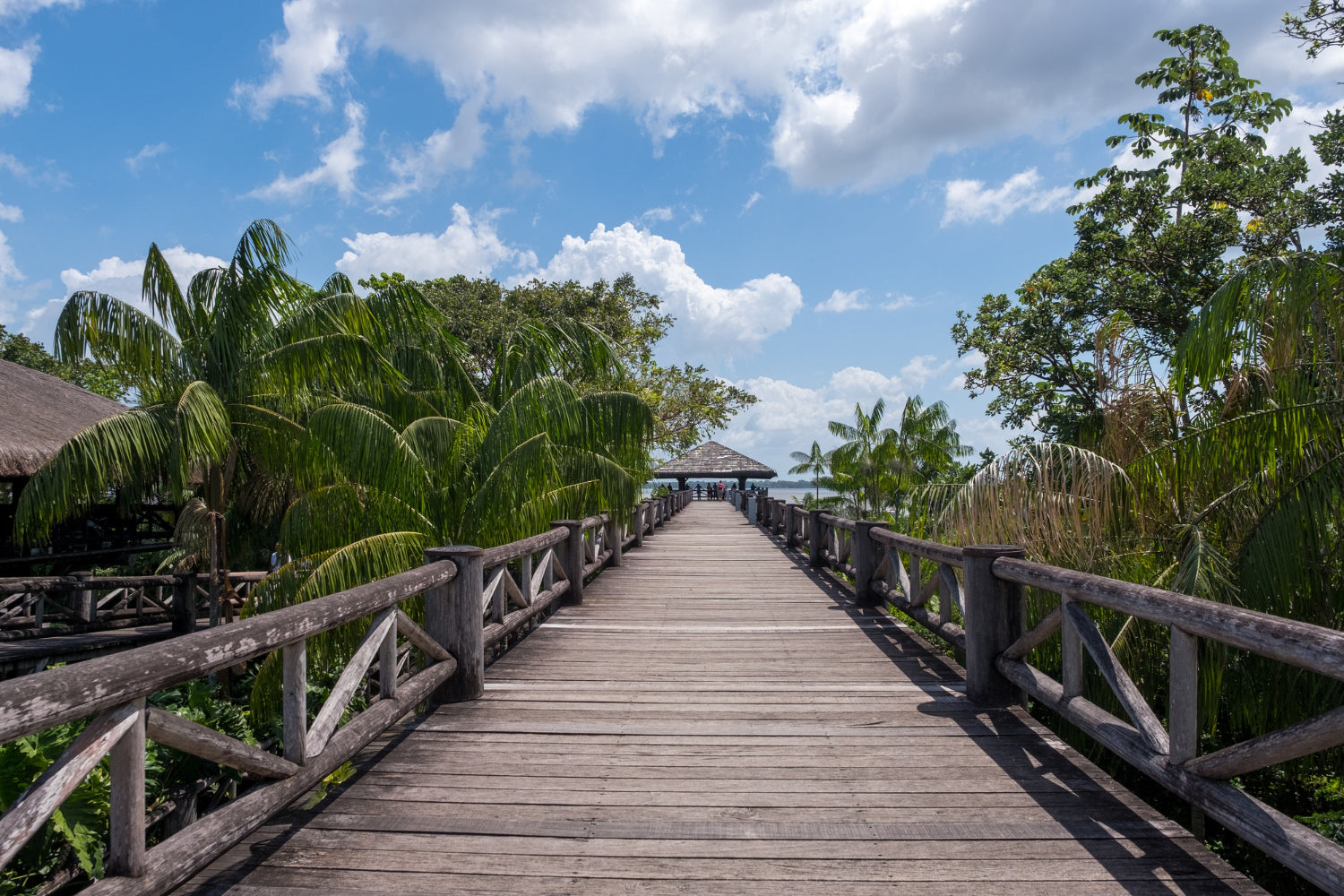 Wooden walkway heading towards a pergola overlooking the sea