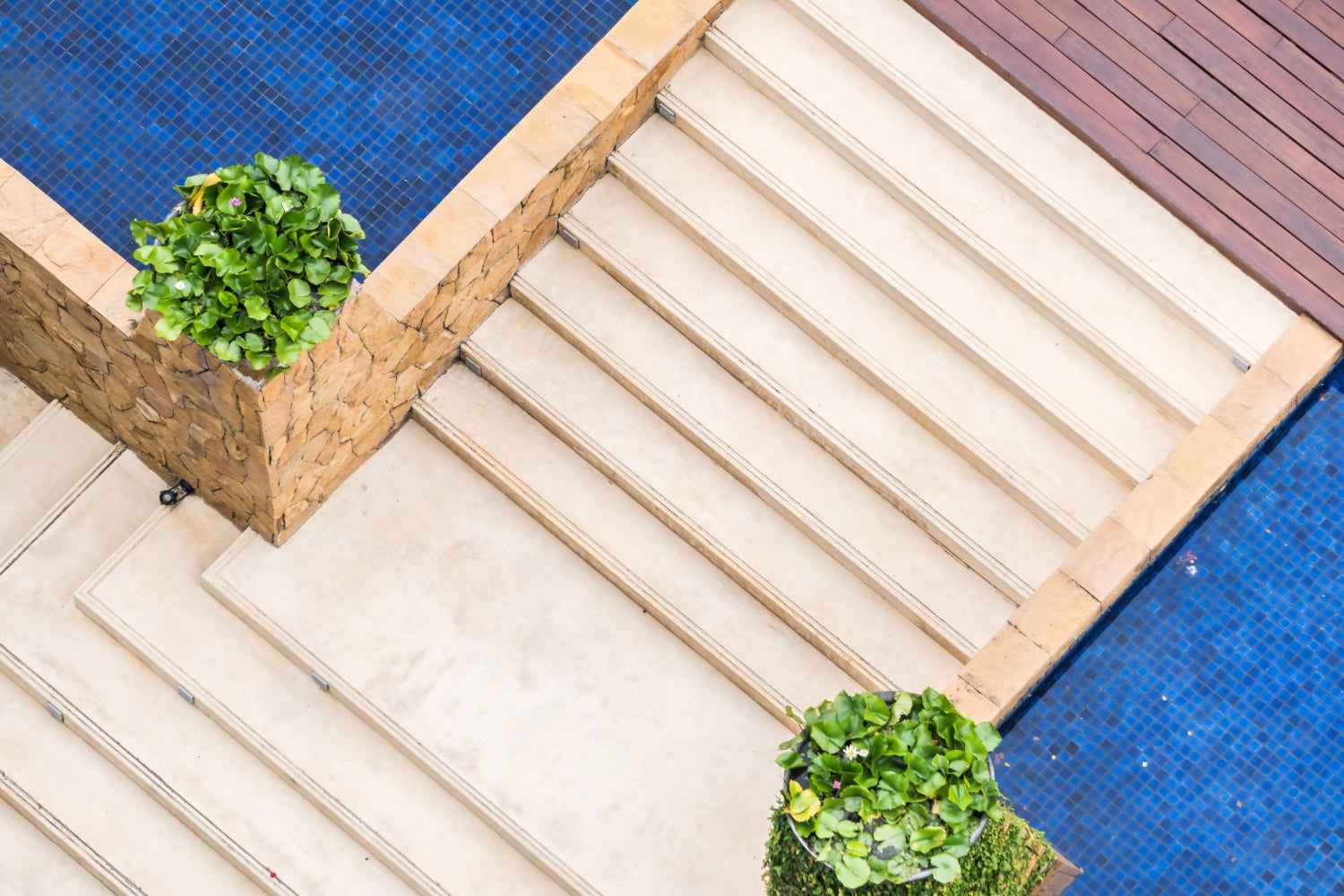 Top down image of a pool with steps up to a deck